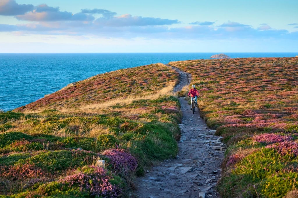 Frau radelt entlang der Küste der Bretagne