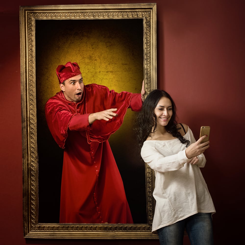 Frau macht Selfie vor Kunstwerk im Museum