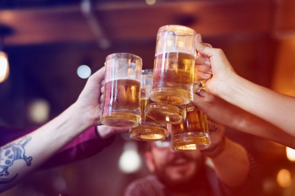 Trinkregeln aus aller Welt: Drei Personen stoßen mit Bier an.