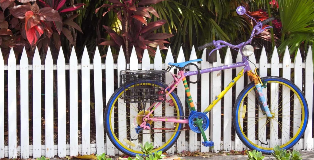 Buntes Fahrrad steht vor einem Holzzaun