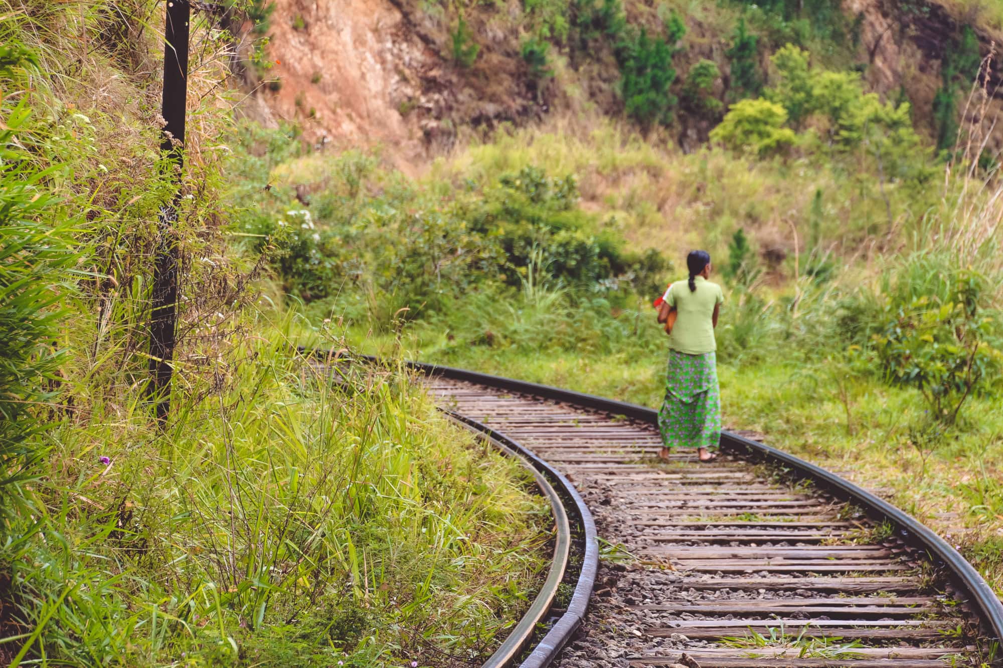 Einheimische Frau spaziert auf den Schinen in Ella, Sri Lanka