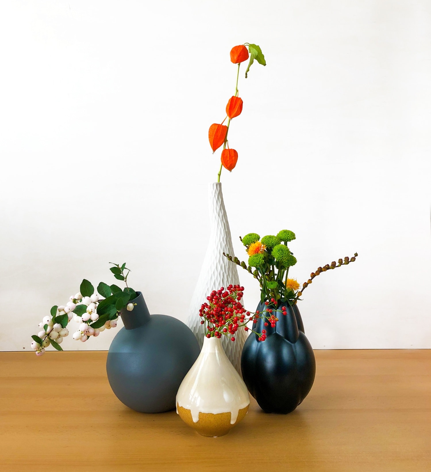 Vier verschiedene Vasen mit unterschiedlichen Blumen