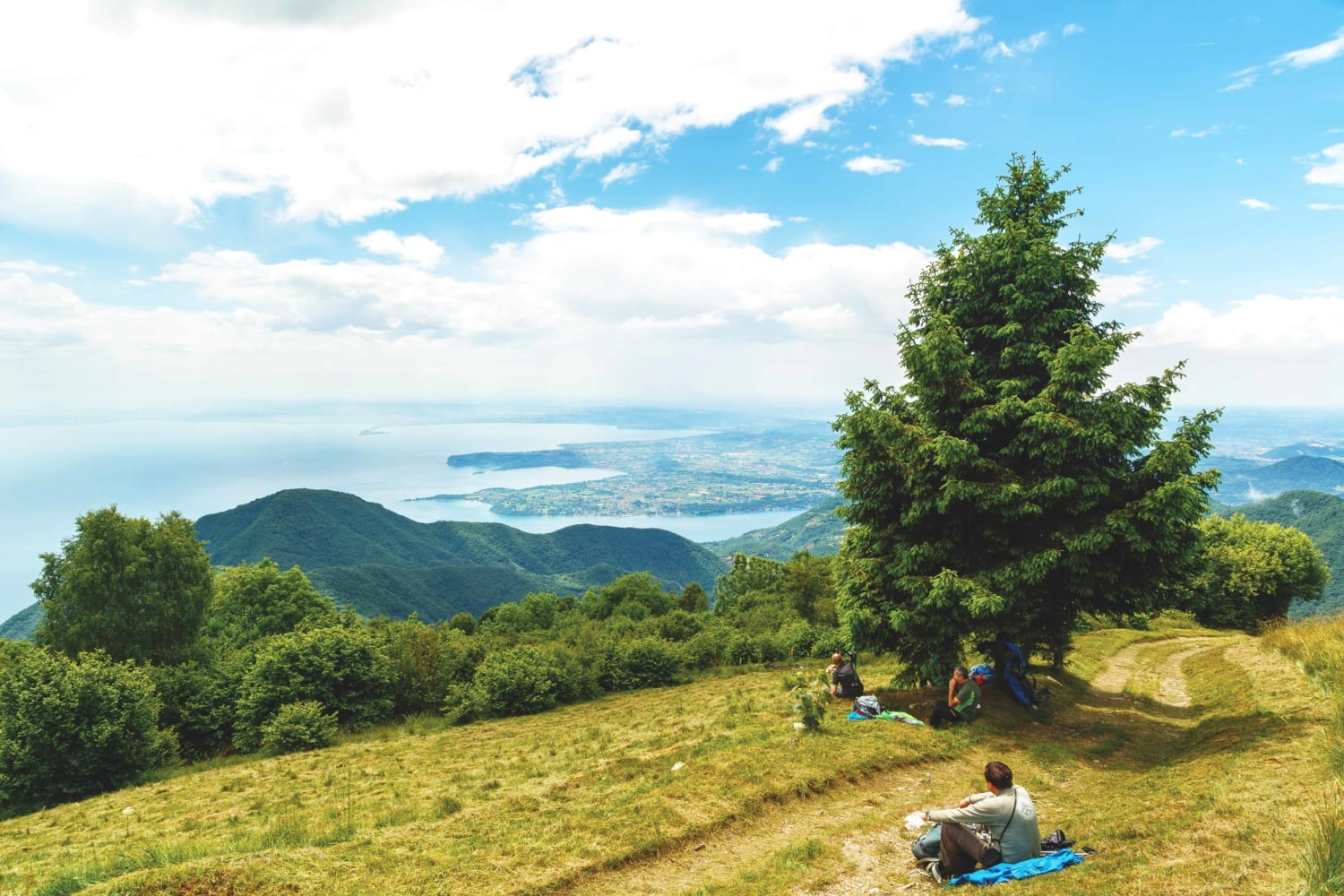 Leute machen auf Wanderpfad Rast und schauen auf den See