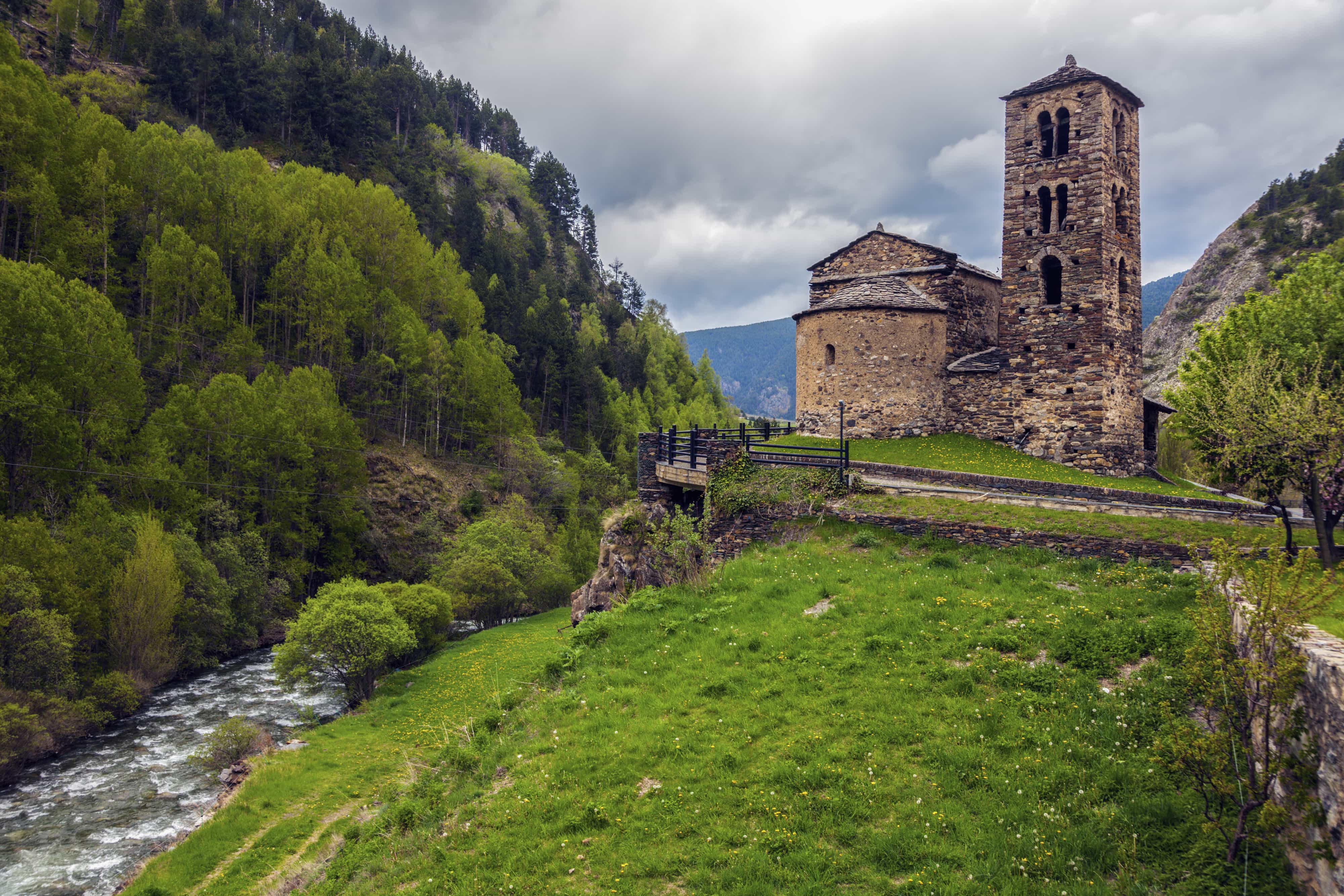 Alte Steinkirche an grünem Abhang und Hügel