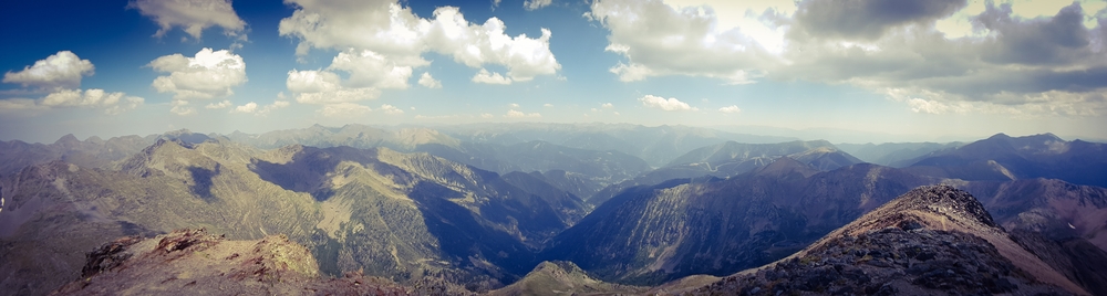Grünes Bergpanorama mit blauem Himmel und Wolken