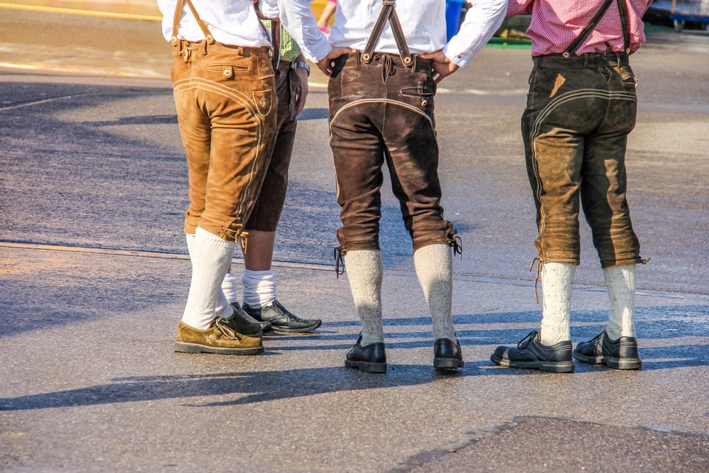 drei Männer von hinten in Lederhosen und Trachtschuhen