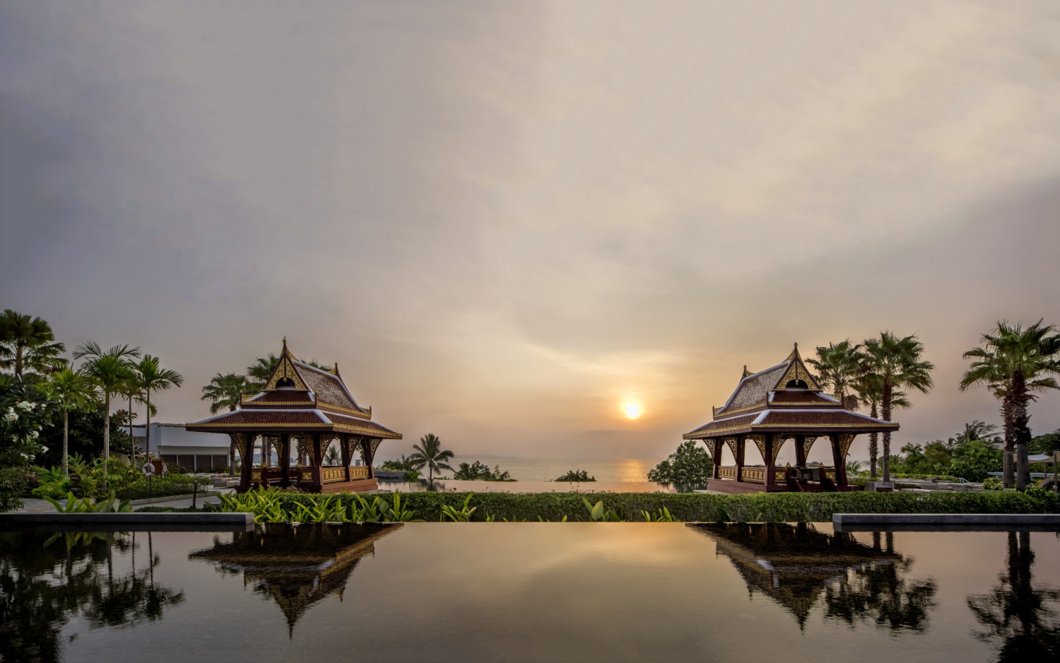 Infinity Pool in Sonnenuntergang und Asiatischen Häuschen