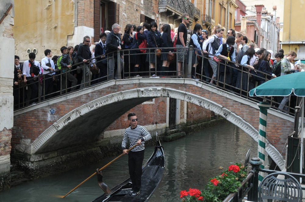 Viele Menschen stehen auf kleiner Brücke und kommen nicht voran.