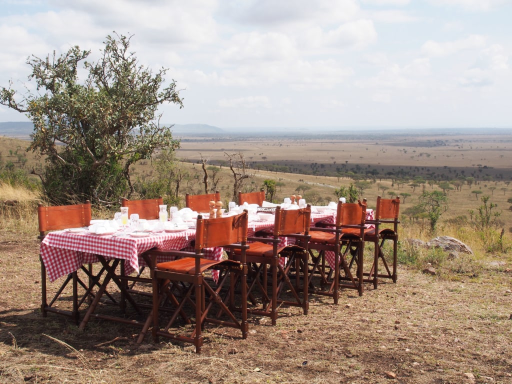 Singend und tanzend wird Autorin Marie Tysiak vom Team des One Nature Nyariuswiga in der Serengeti zu einem Busch-Frühstück überrascht.