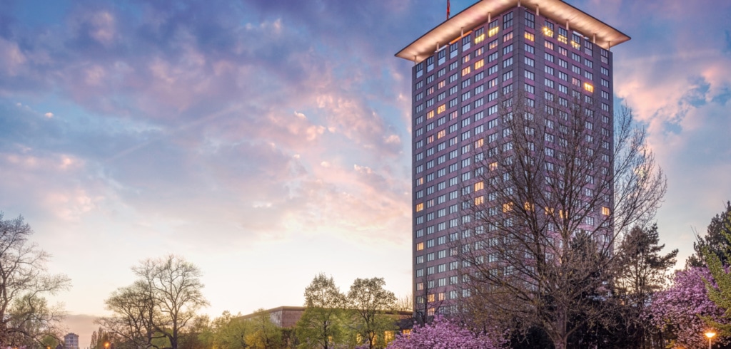 Hohes Hotelgebäude an Kanal im Abendlicht.