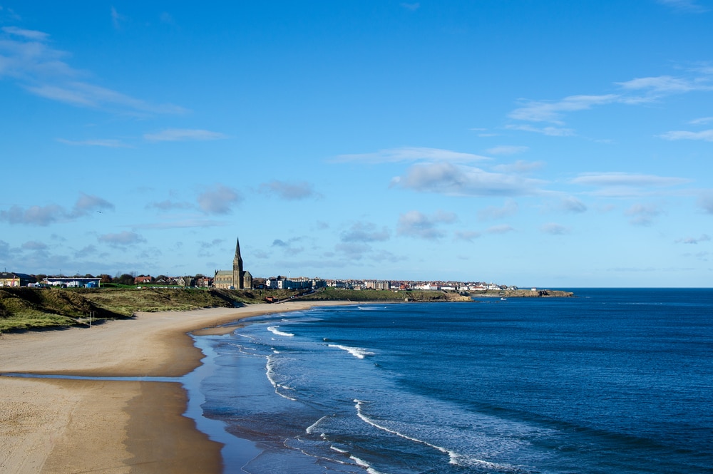 Einsamer Strand mit Dünen und Kirche.