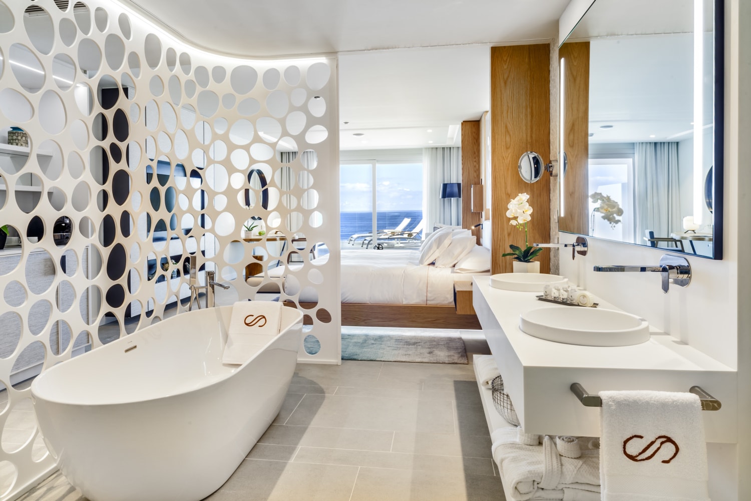Luxussuite mit großer Badewanne und Blick aufs Meer.