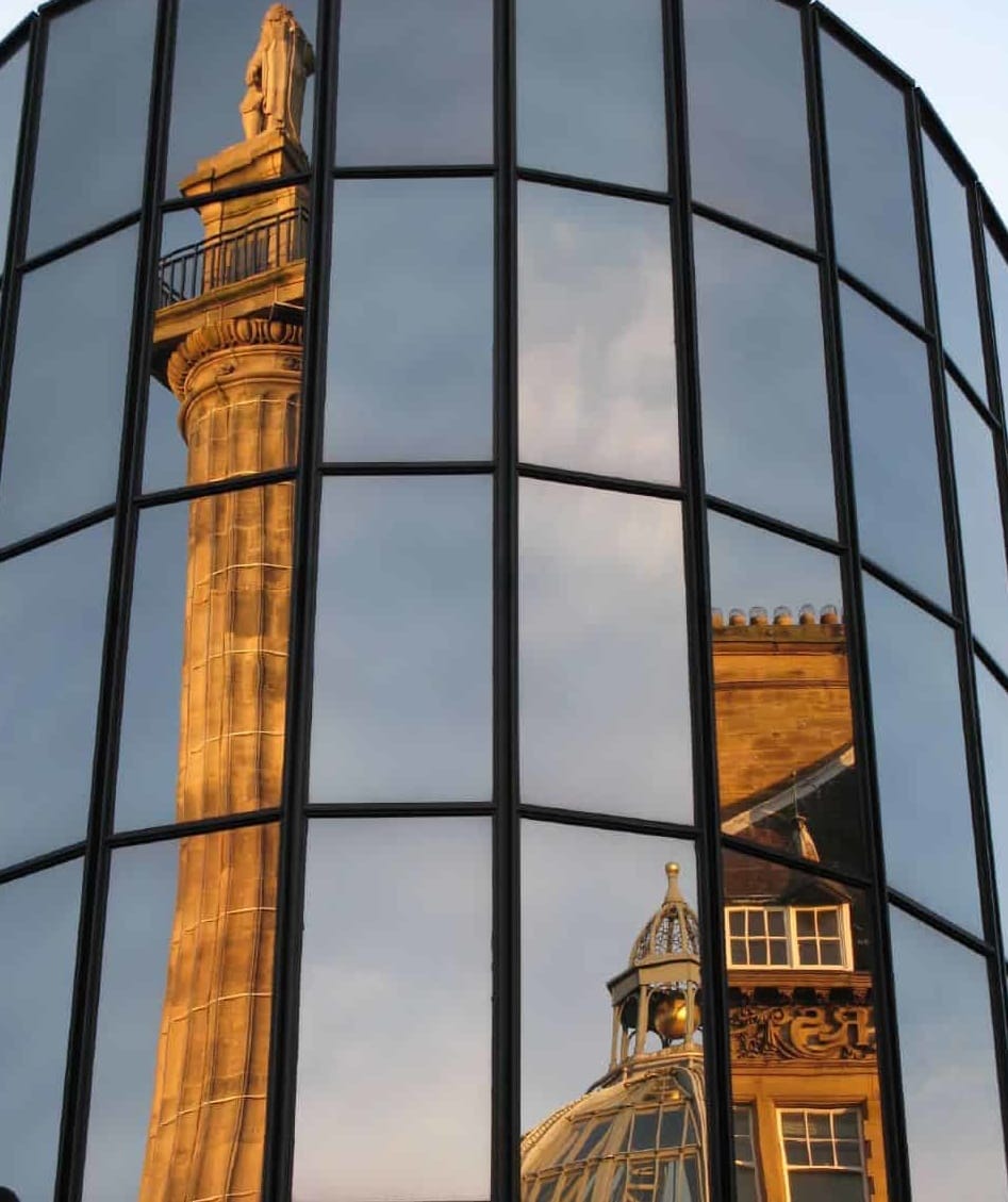 Alte Gebäude spiegeln sich in neuem verspiegeltem Gebäude