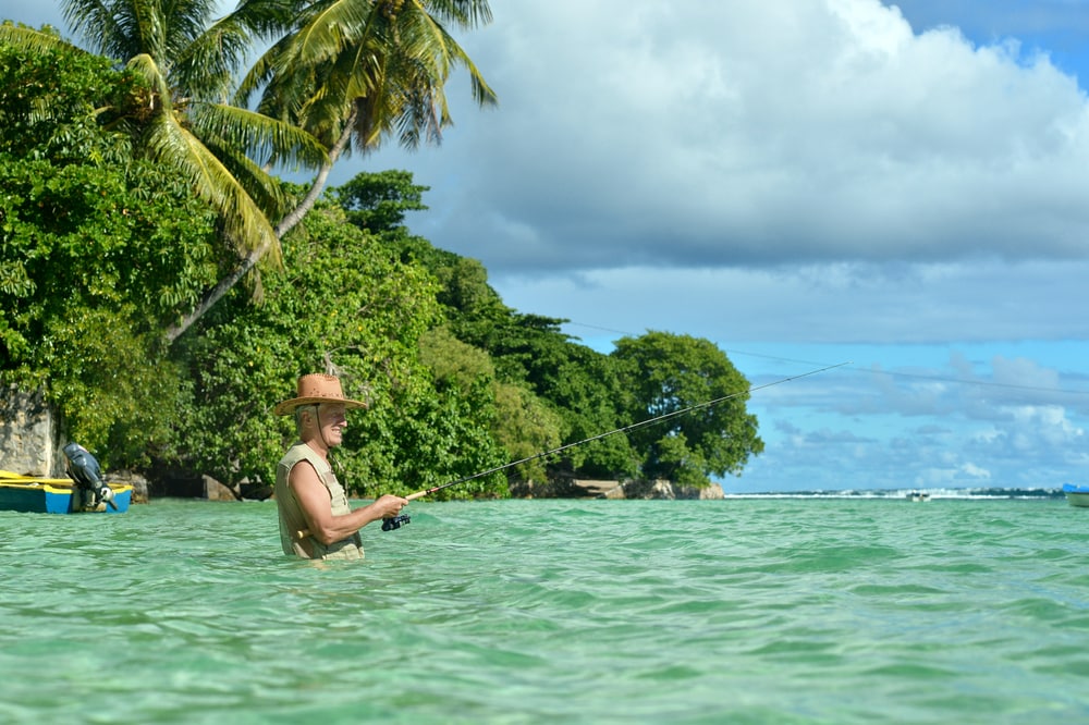 Älterer Mann im Meer beim Angeln