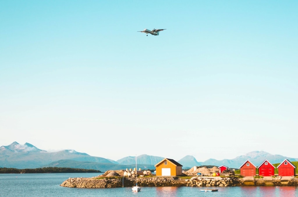Fjord in Norwegen mit Holzhütte, blauer Himmel, Flugzeug