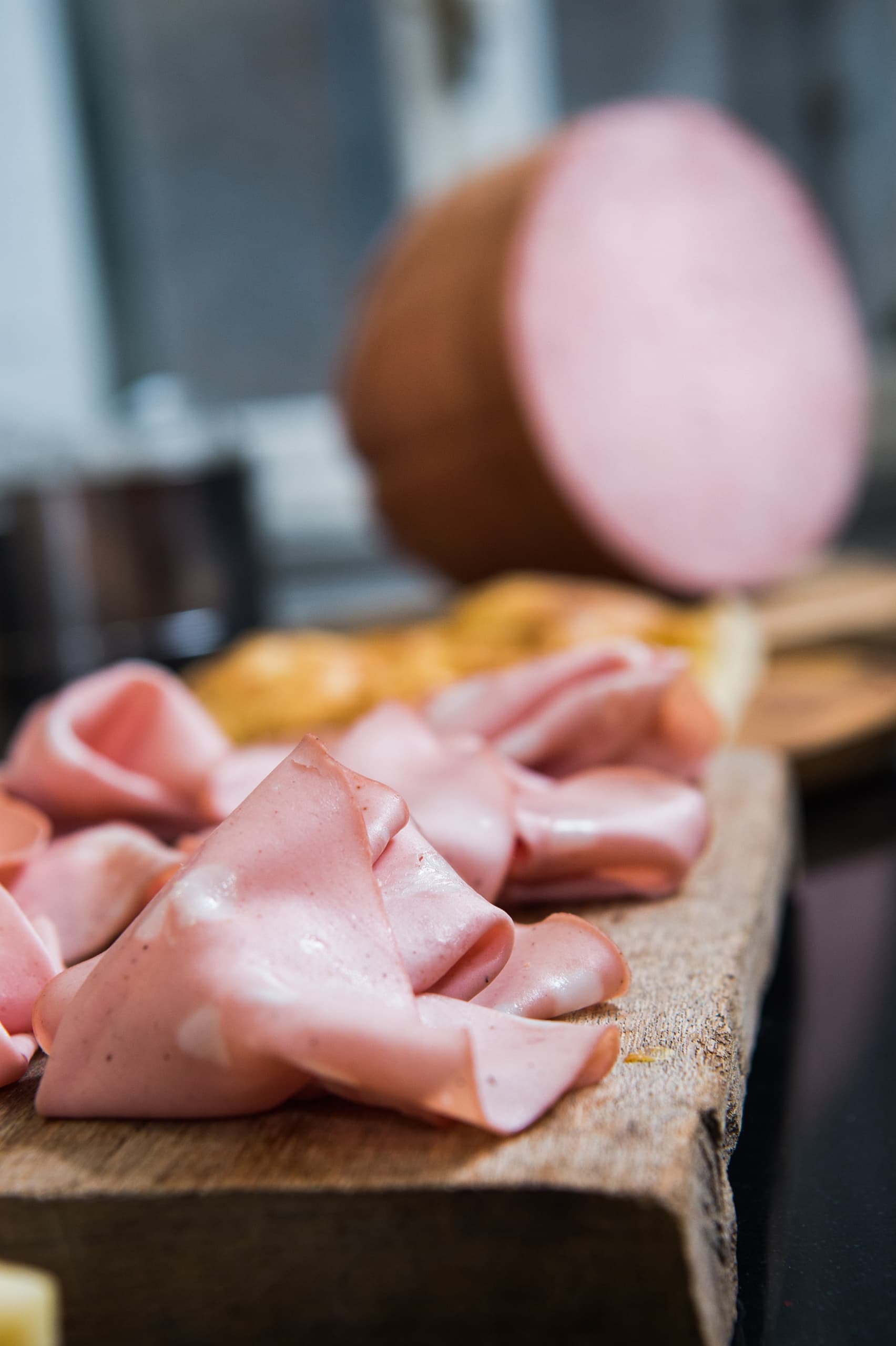 Fein geschnittene Mortadella serviert auf einem Holzbrett