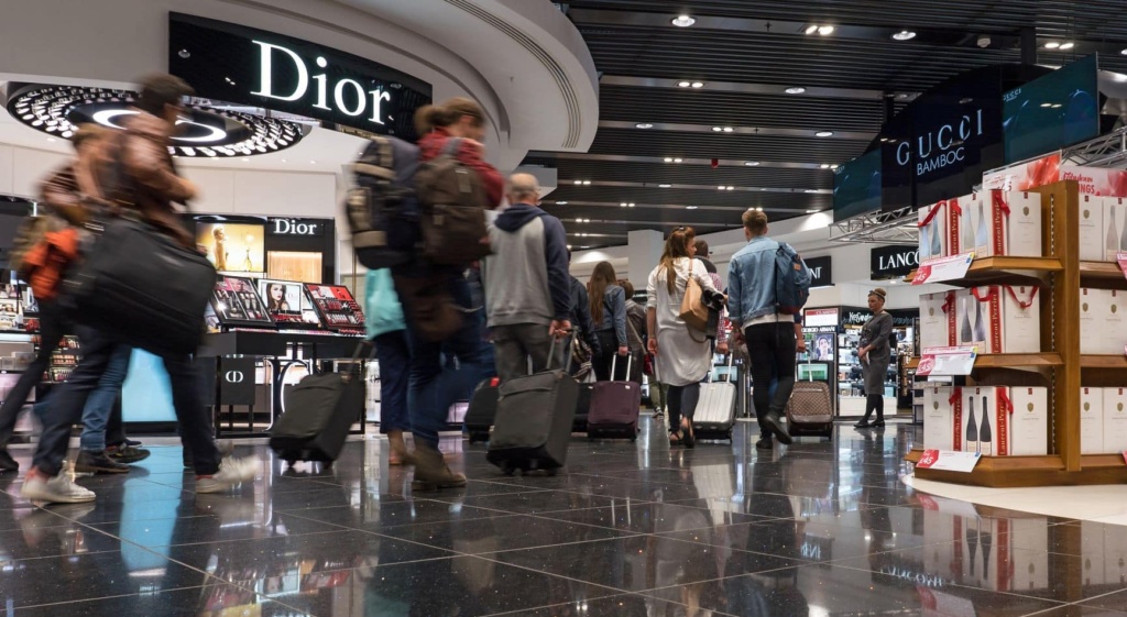 Passagiere laufen am Dior-Shop im Flughafen London vorbei