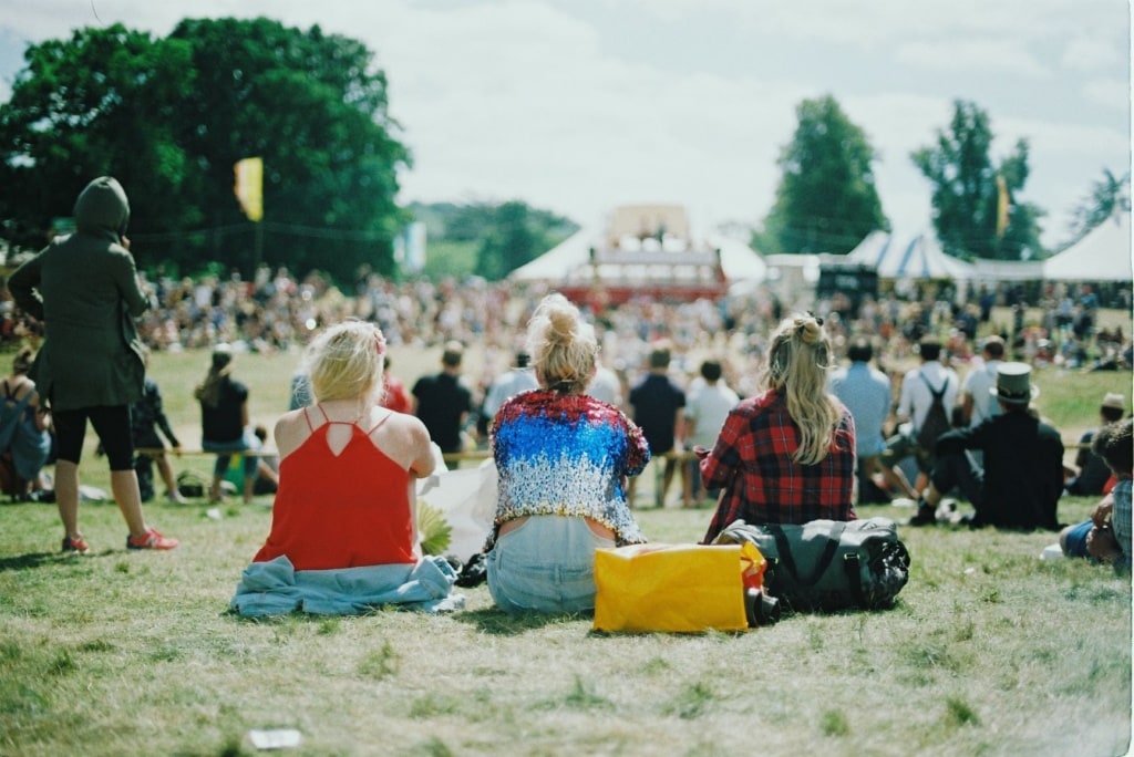 Festivalbesucherinnen auf Wiese sitzend