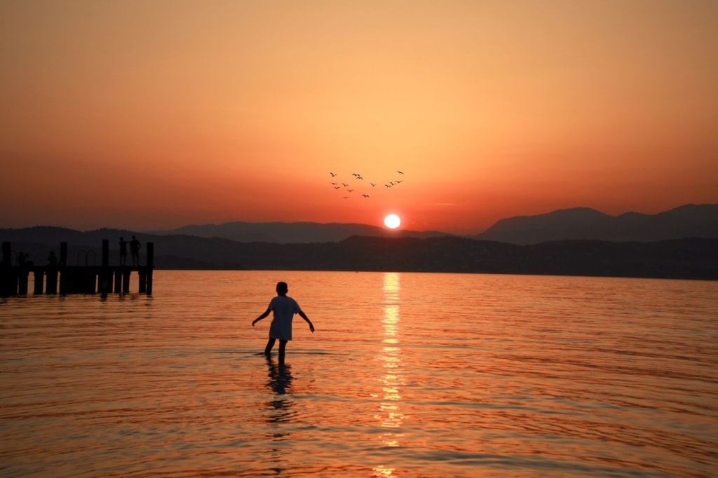 Junge bei Sonnenuntergang im Gardasee