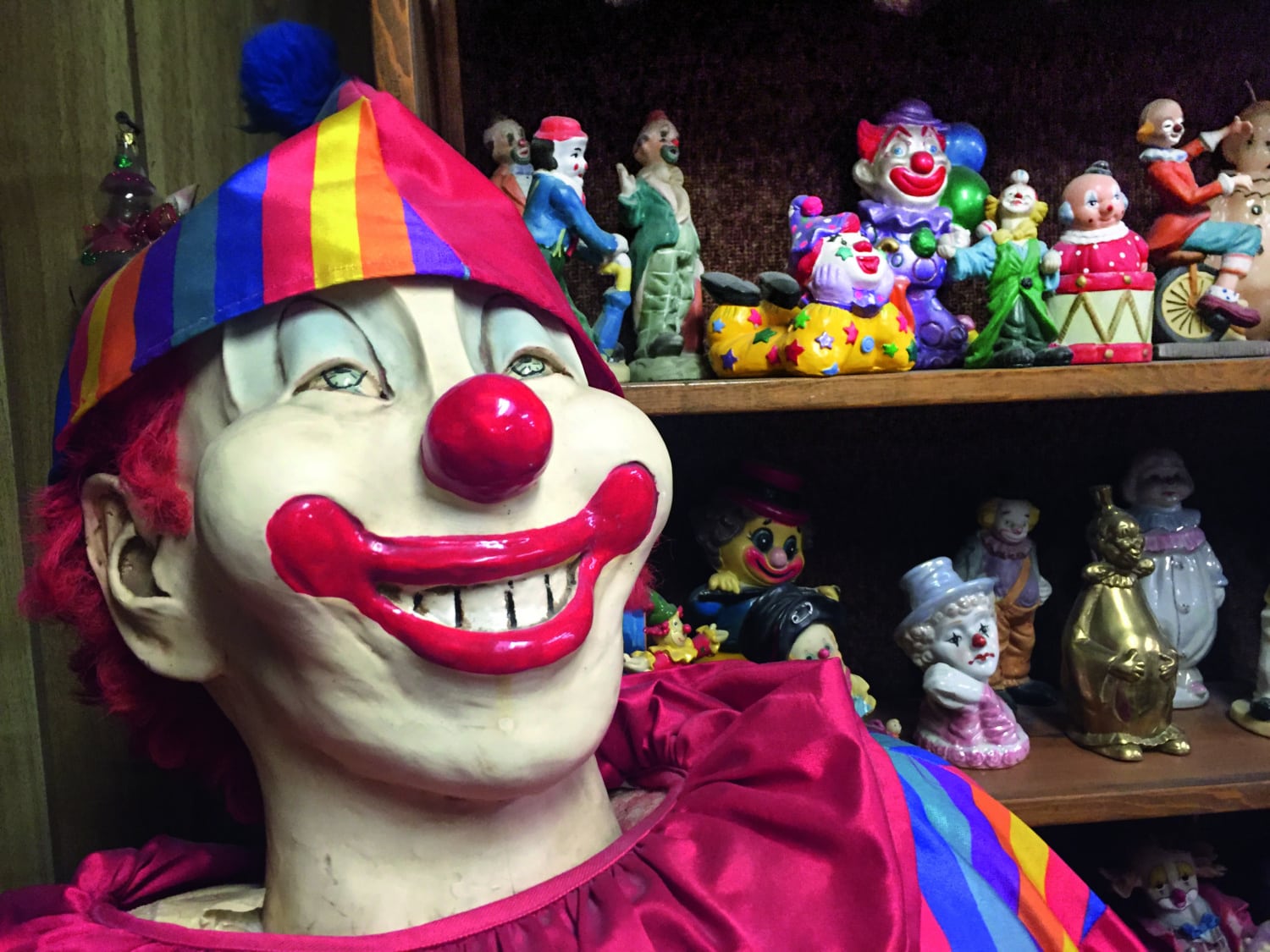 Große Clown-Figur grinst in Kamera