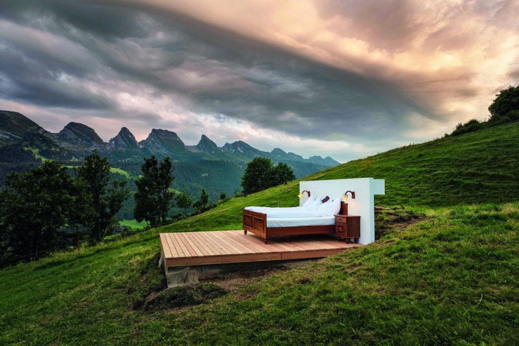 Uriges bett steht mitten in grüner Landschaft