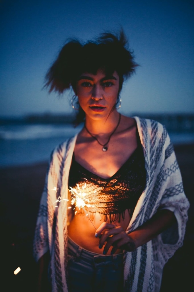 Frau mit Wunderkerze am Strand