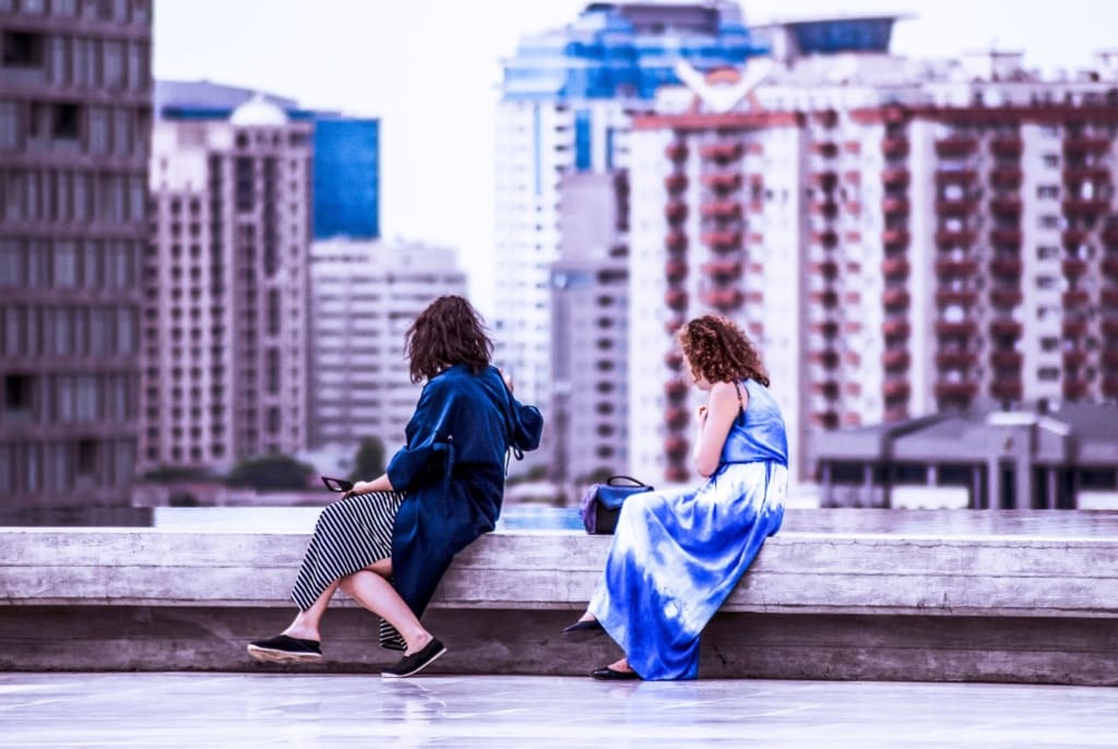 Zwei Frauen sitzen auf Mauer in Baku, Aserbaidschan