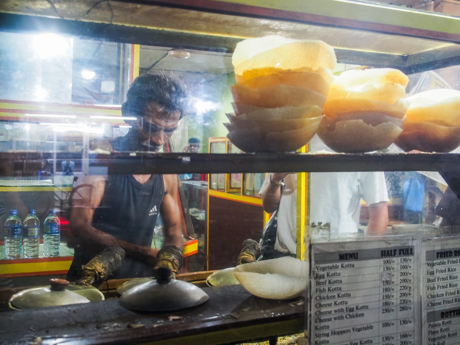 Srilankischer Mann brät Hoppers an einem Street Food Stand
