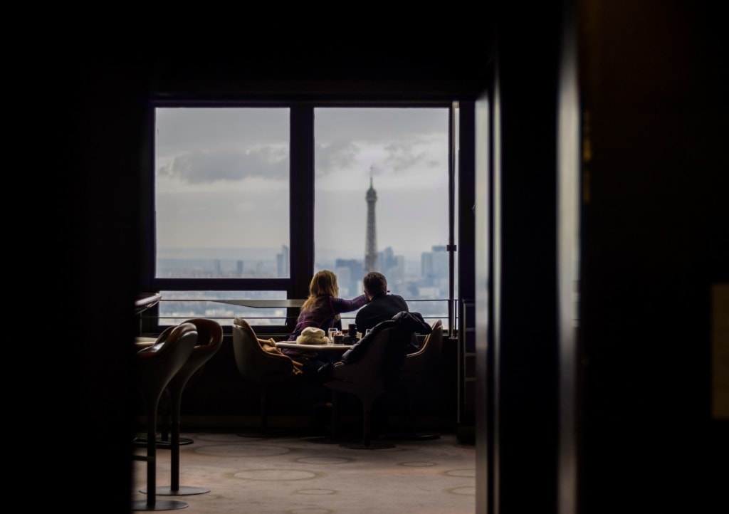Mann und Frau sitzen auf Sesseln in einer Hochhaus-Bar