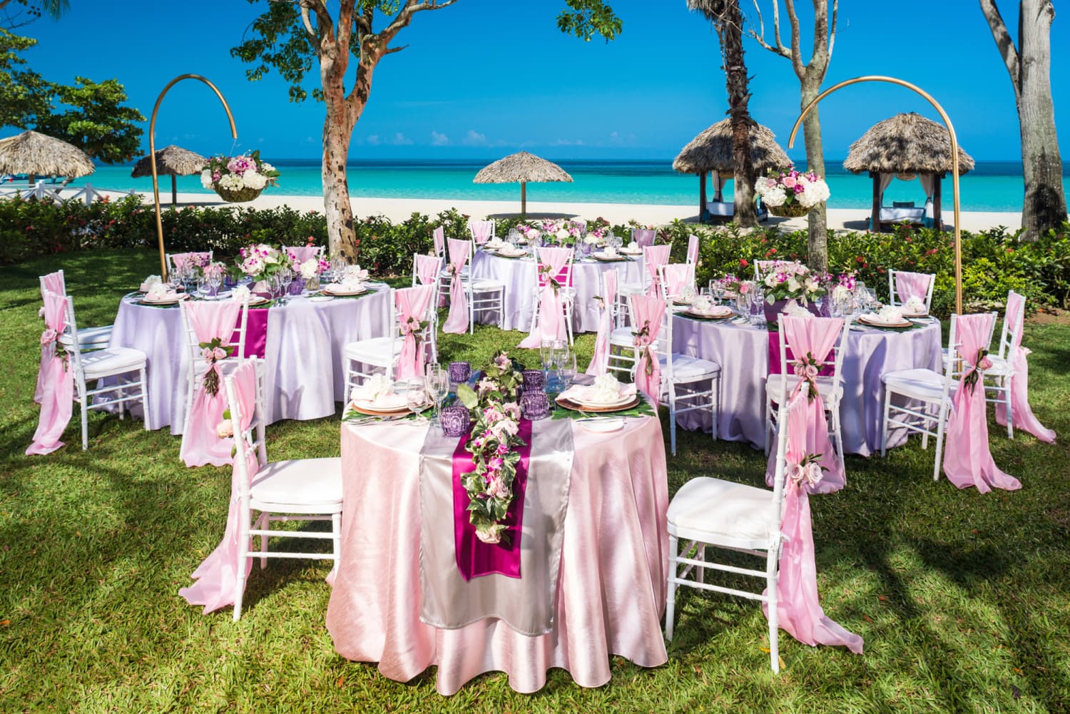 In Farbe pink gedeckte Tische bei Hochzeit am Strand