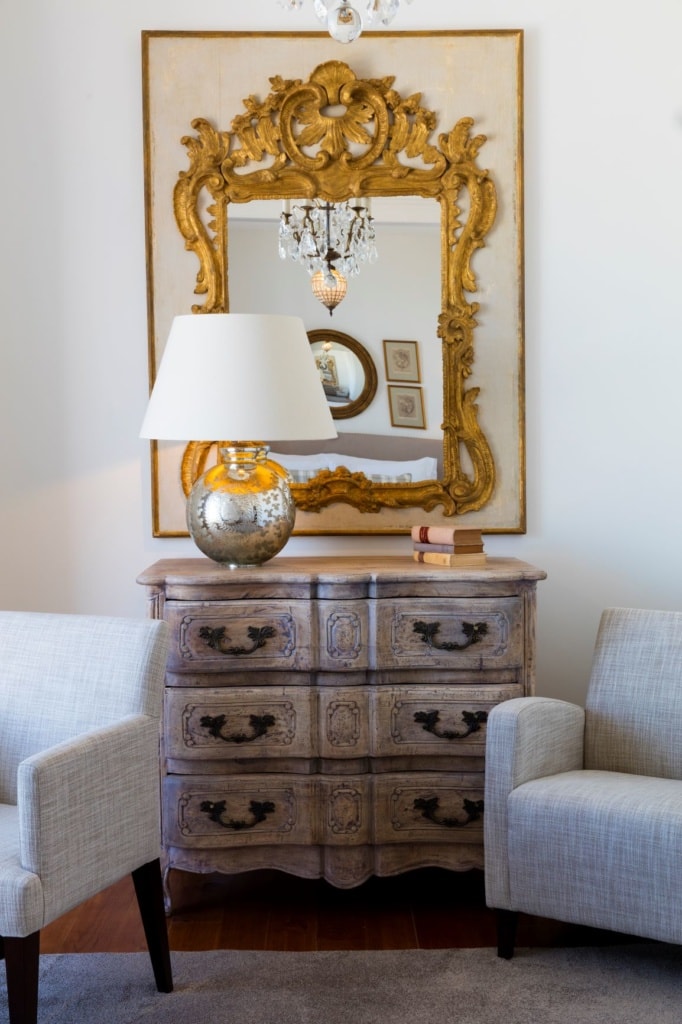 Kommode, Sessel und Spiegel in einem Zimmer im Grand House Algarve