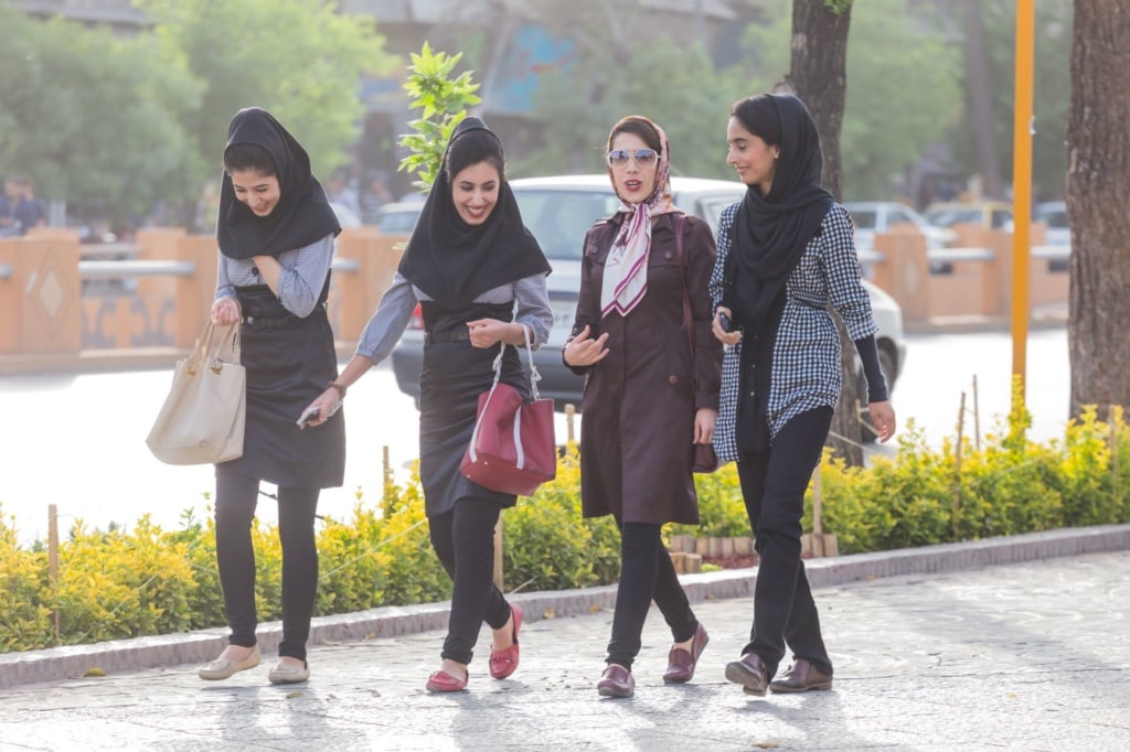 Junge Frauen im Iran spazieren auf Bürgersteig