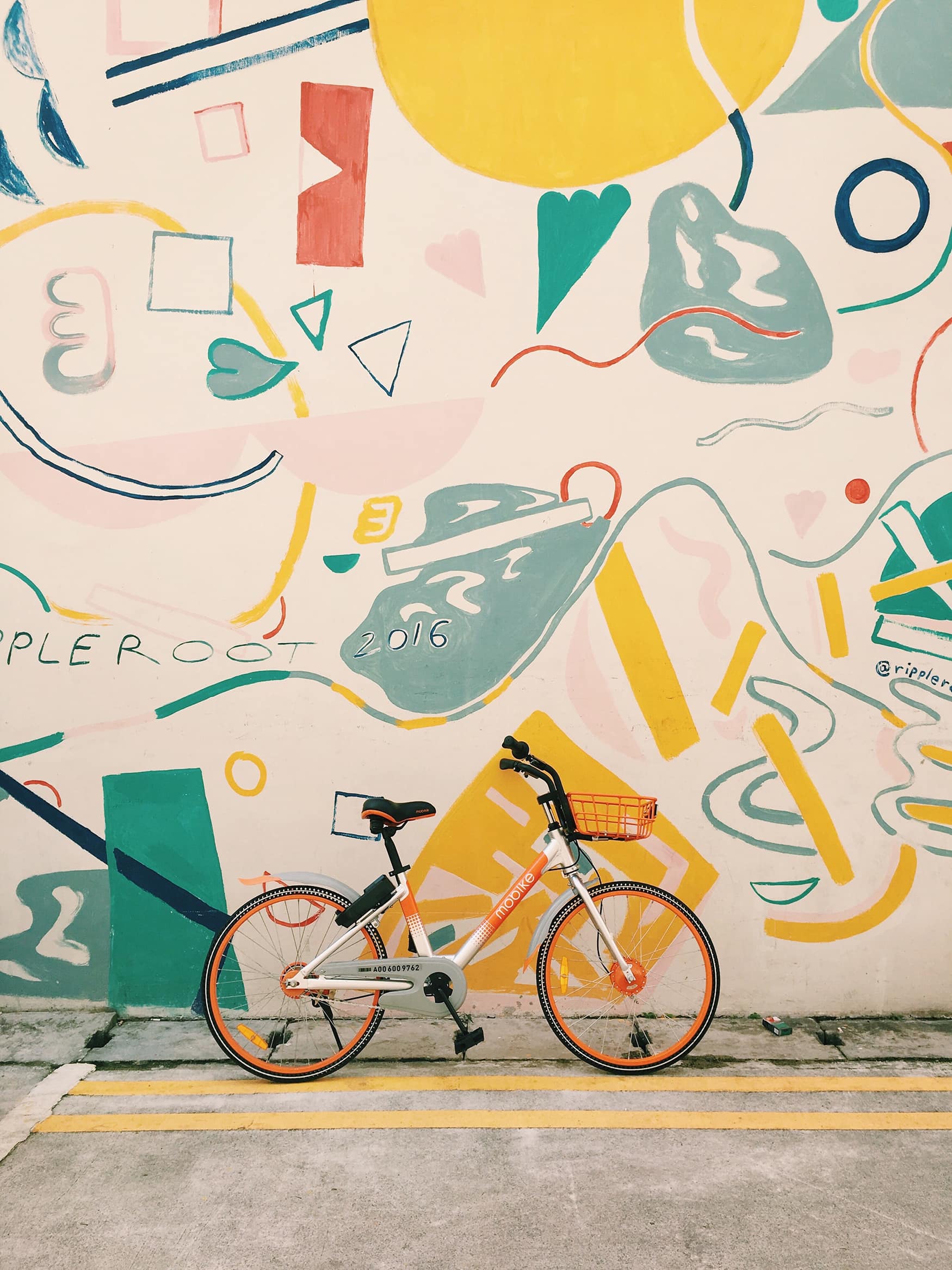Fahrrad lehnt an bunter Hauswand in Singapur