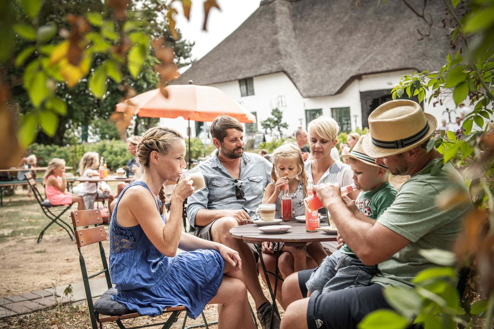 Familie an einem Tisch in einem Hofcafe in St. Peter-Ording