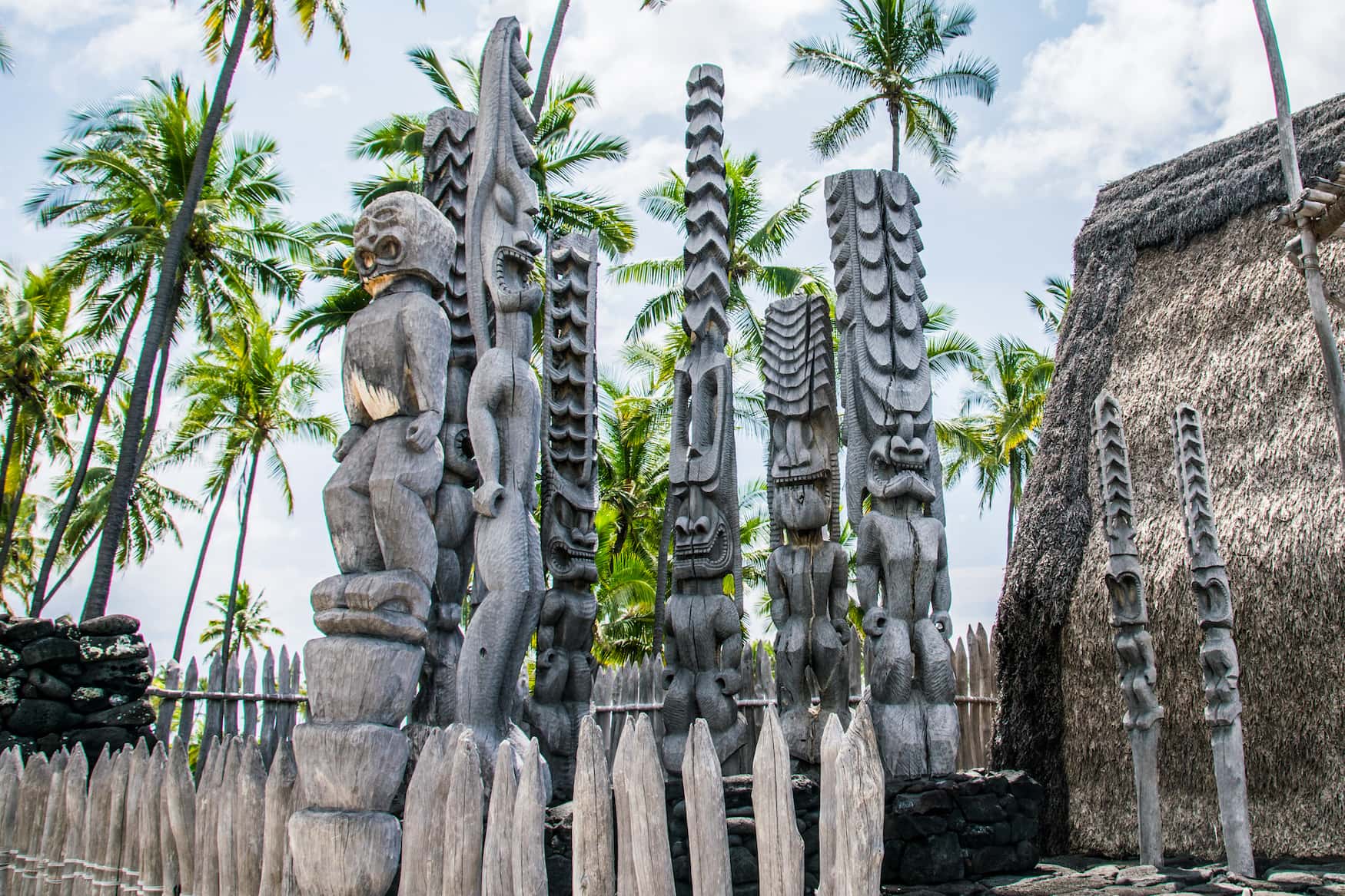 Uralte Tiki-Holzschnitzereien im polynesischen Stil grüßen die Besucher des Ki'i Pu'uhonua O Honaunau Nationalparks auf der Big Island von Hawaii.