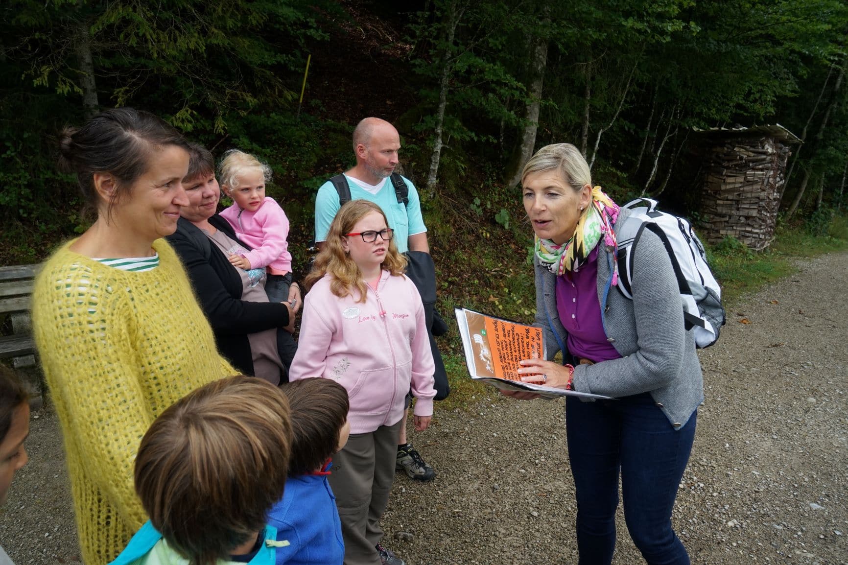 Marlies Speichern mit Buch in Hand vor Kindern beim Wandern