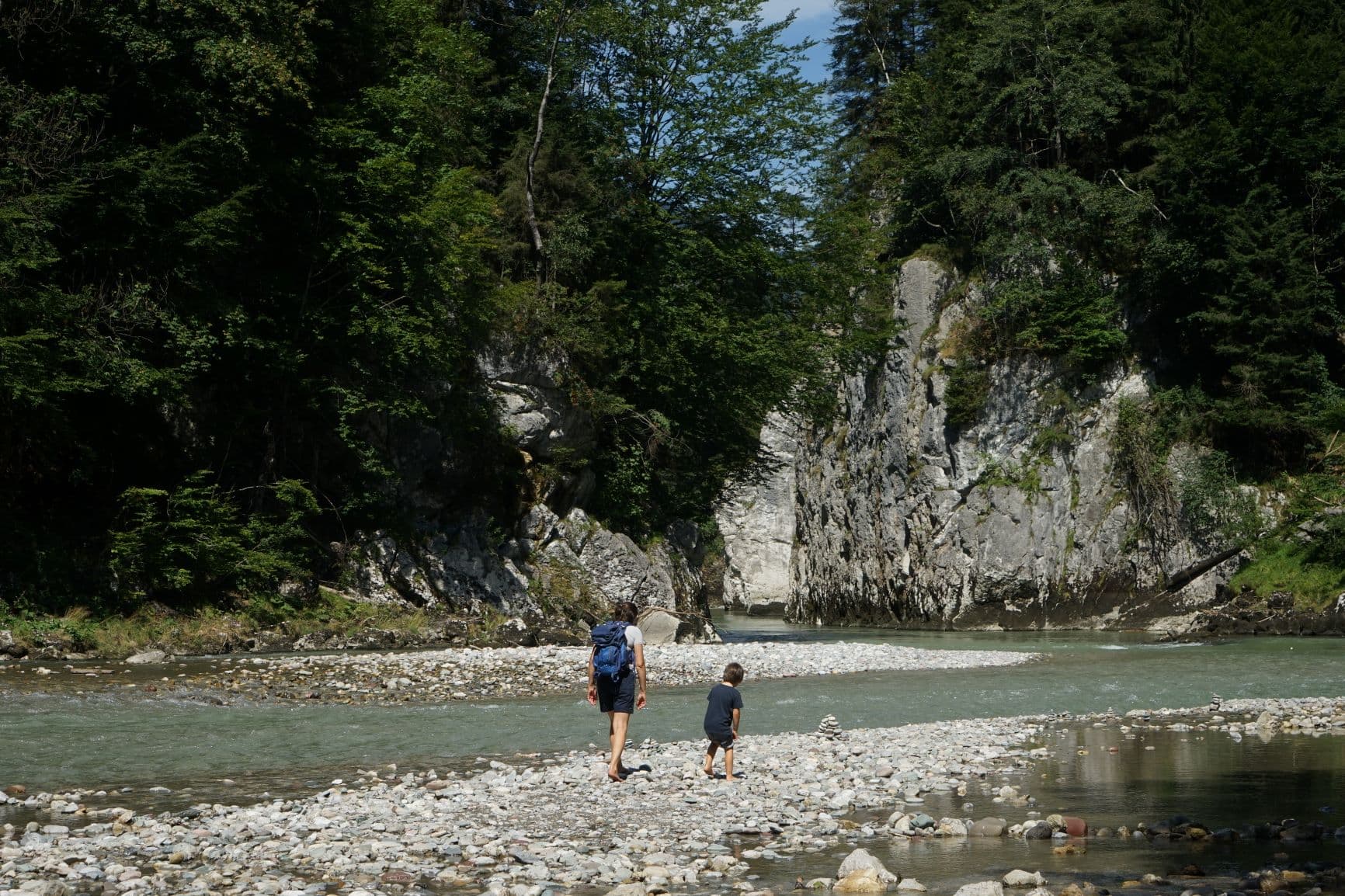 Mutter mit Kind beim Wandern am Fluss