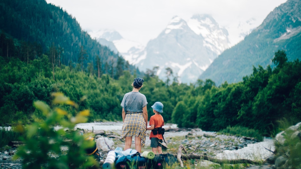Vater und Sohn beim Wandern vor Gebirgskette