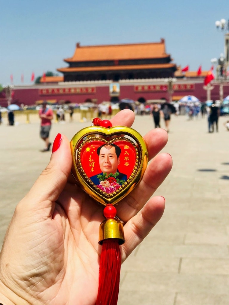 Frau hält Anhänger mit Bildnis eines Politikers in Peking in der Hand