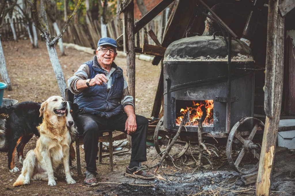 Mann mit Hunden Schnaps brennen