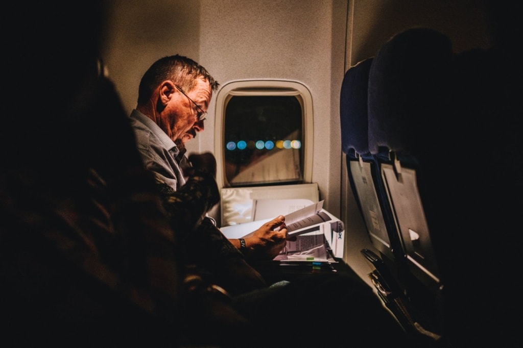 Passagier im Flugzeug, der Dokumente liest