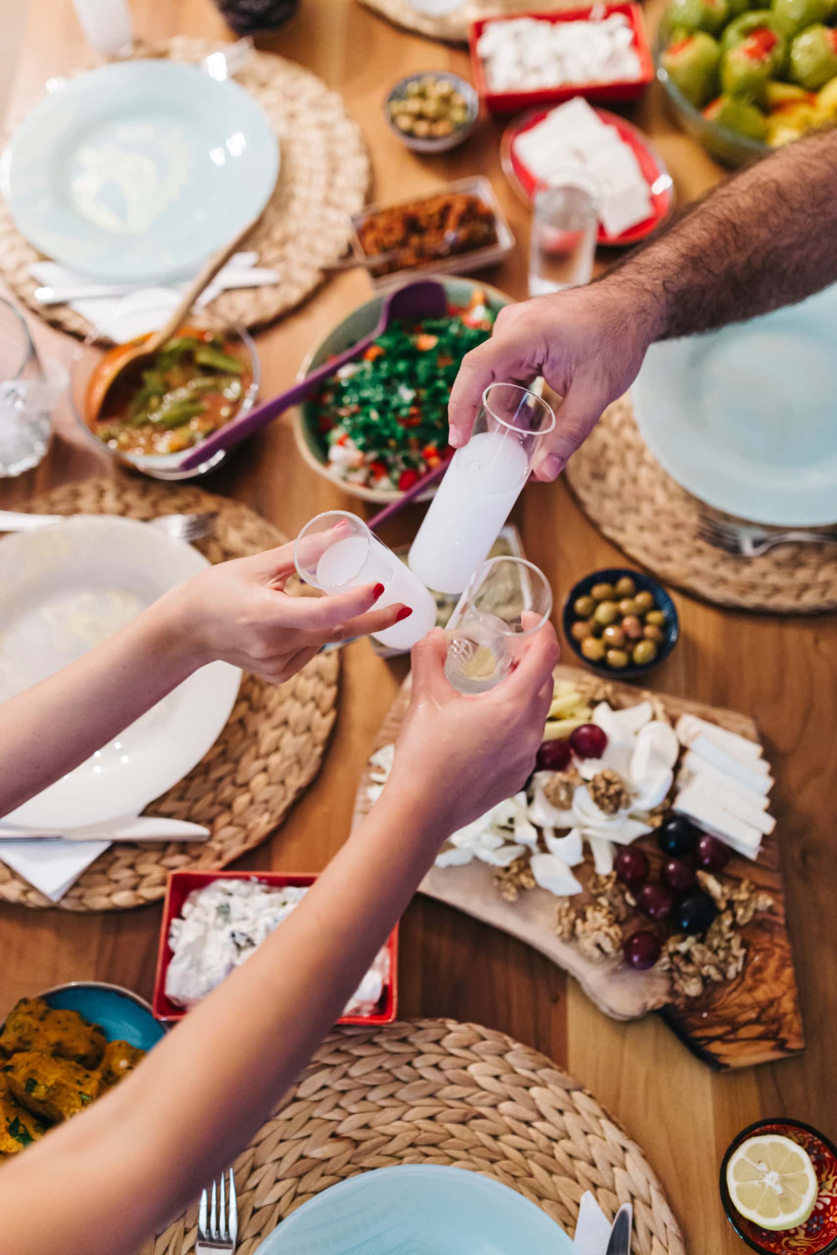 Freunde stoßen beim Abendessen mit Raki an