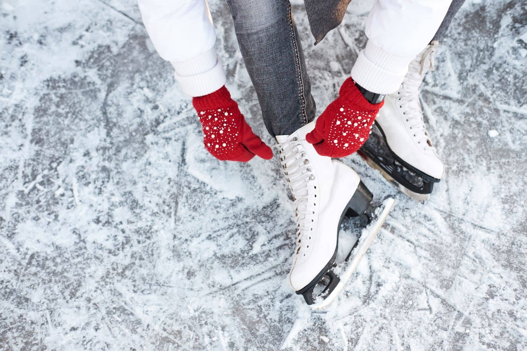 Frau schnürt sich ihre Eislaufschuhe