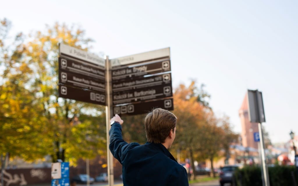 Mann zeigt auf Schild in Danzig