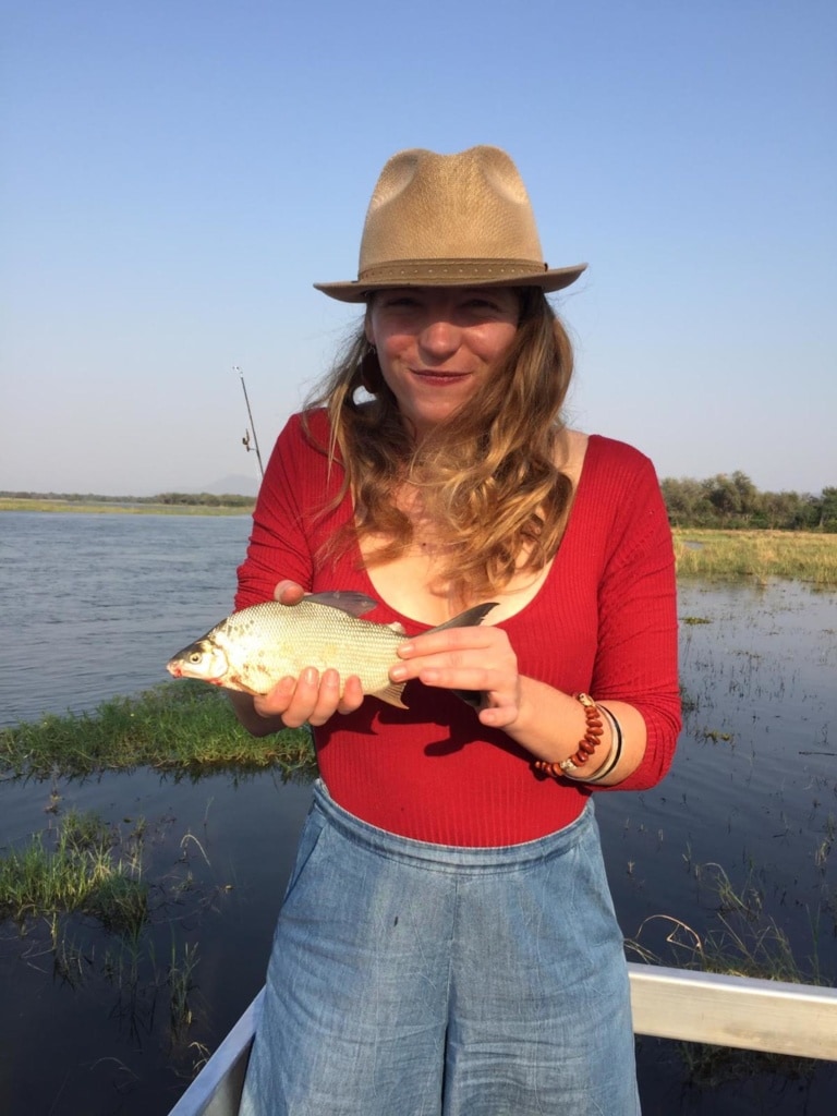 Autorin Marie zeigt stolz ihren Fisch, den sie auf dem Sambesi geangelt hat.