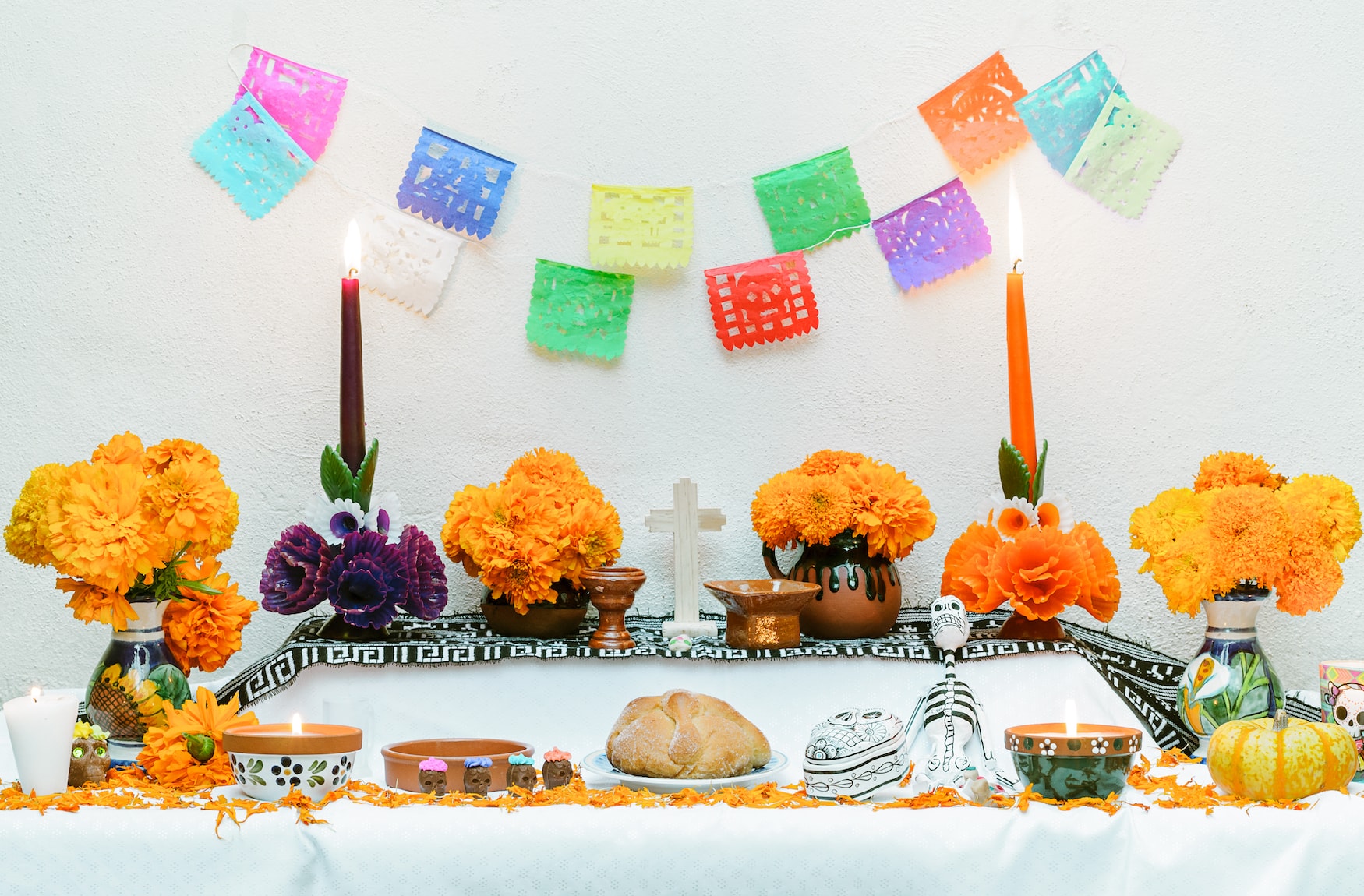 Papiergirlanden und Pan de Muerto auf einem Altar am tag der Toten in Mexiko