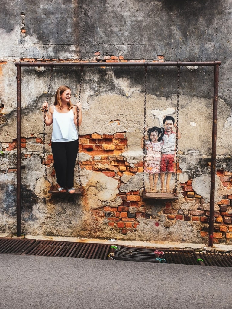 Redakteurin Linda schaukelt mit den Kindern, die als Street-Art in Georgetown zu finden sind