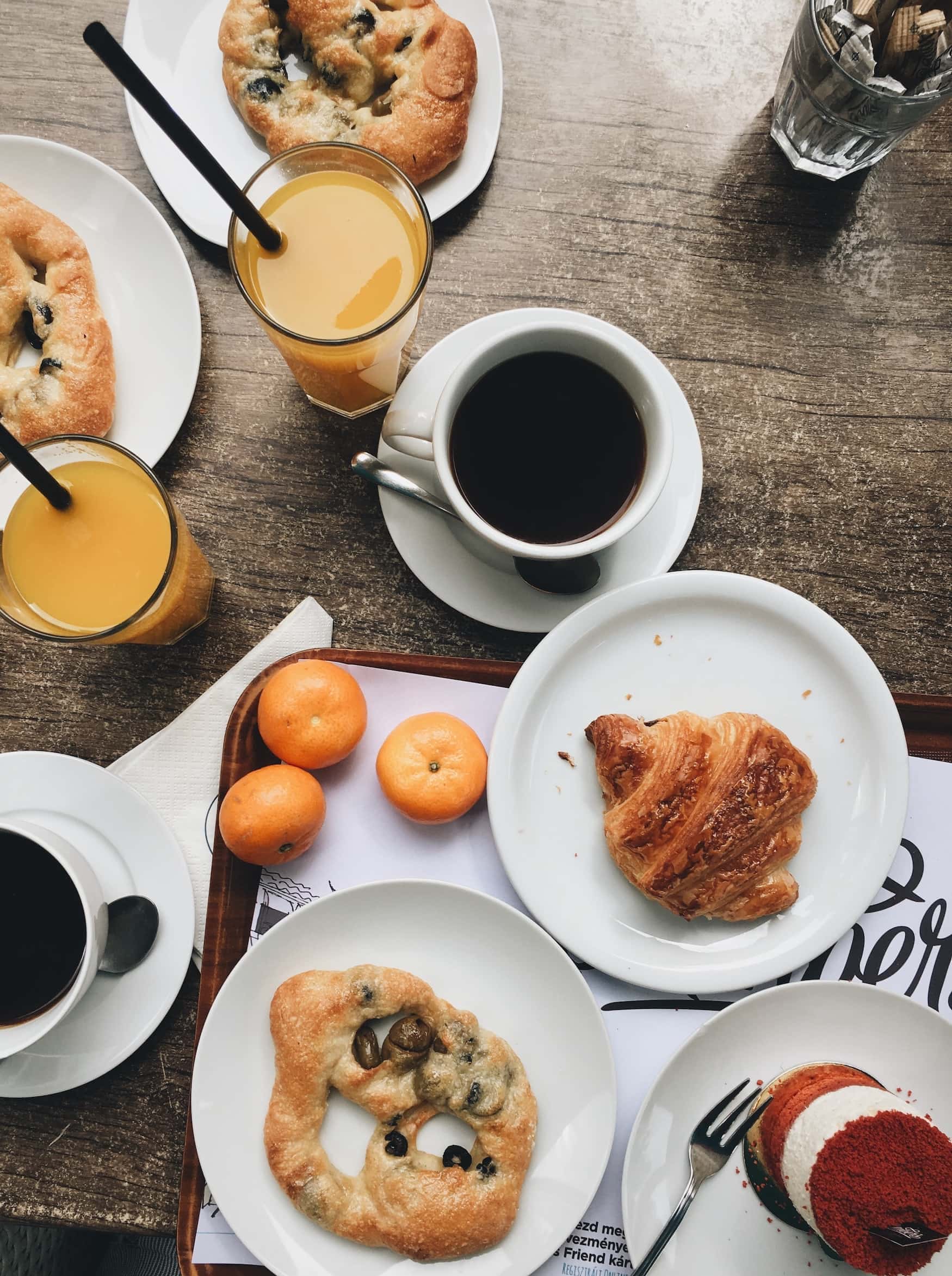 Frühstück mit Kaffee, Orangensaft und süßem Gebäck