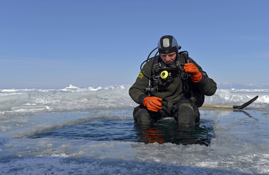 Und rein ins kalte Wasser: Der erste Taucher traut sich ins Eisloch im Baikalsee.