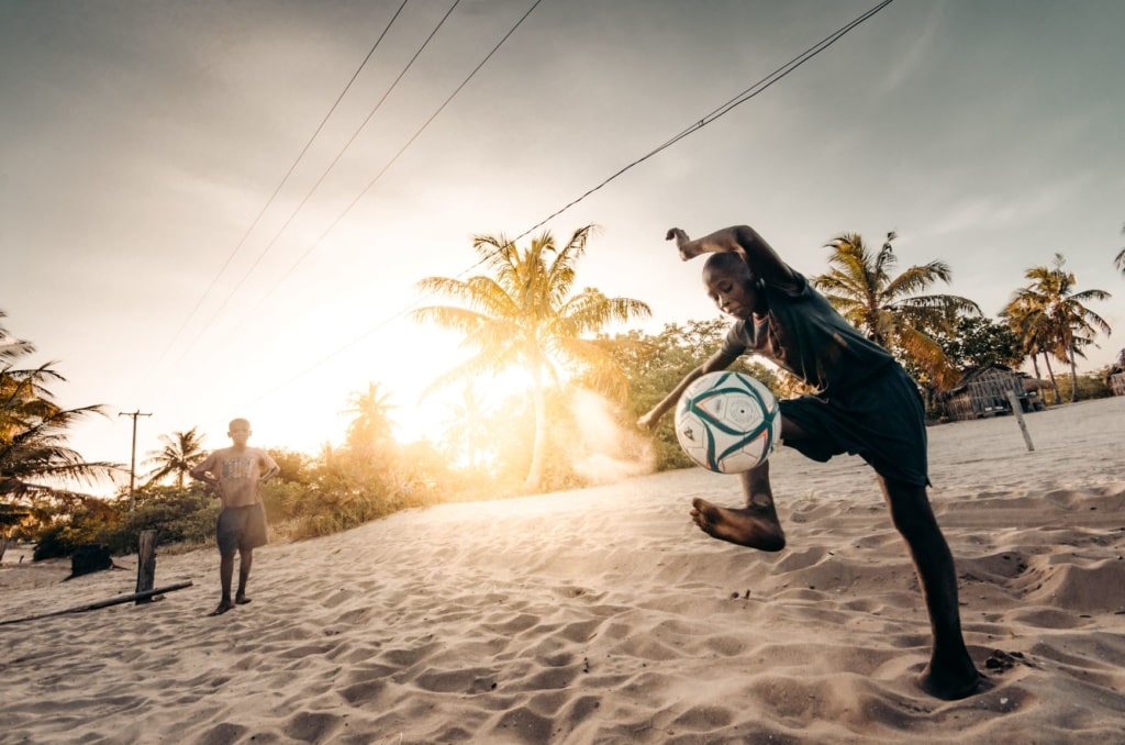 Kinder in Mosambik spielen Fußball am Strand